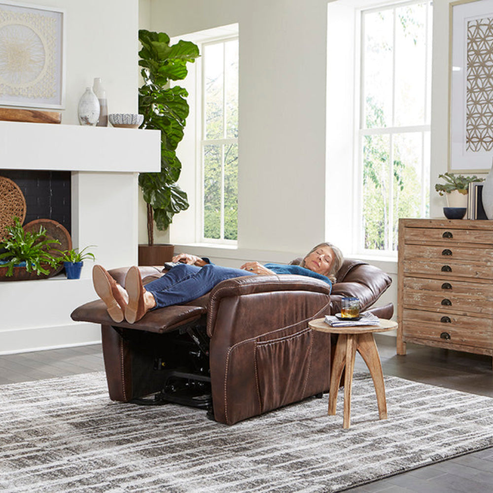 Woman lying back in a brown Golden Dione PL446 lift chair at home